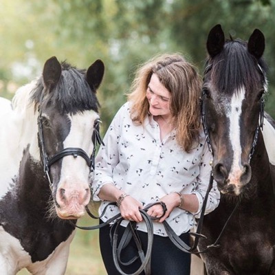 Rhea Freeman standing between her two coloured horses